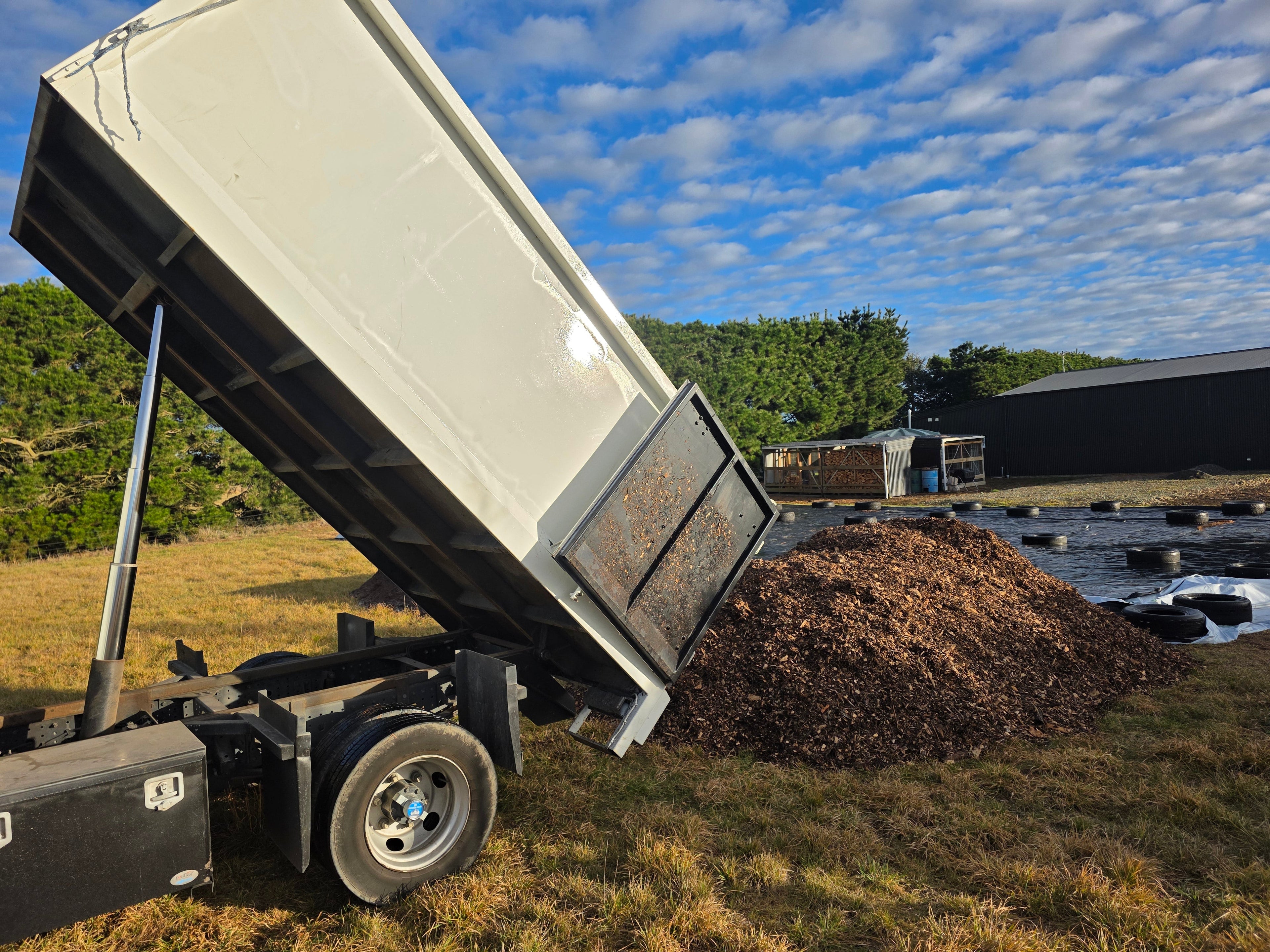 load of aged mulch being tipped out of a white truck